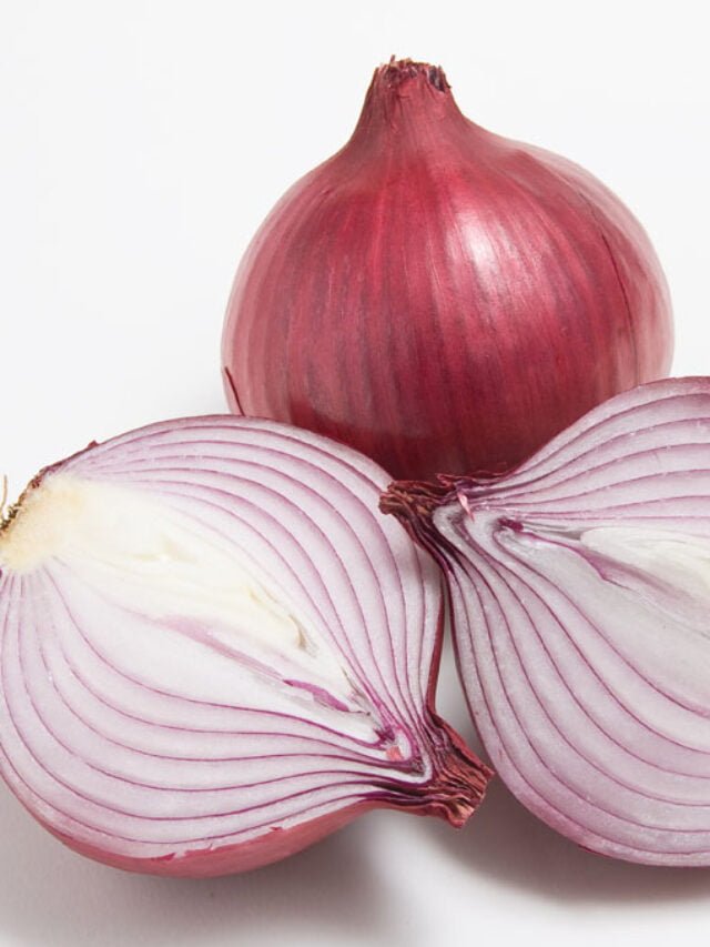 A red onion with an onion cut in half on a white background.